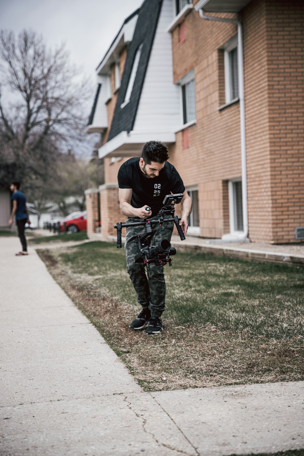 man using drone standing in green field