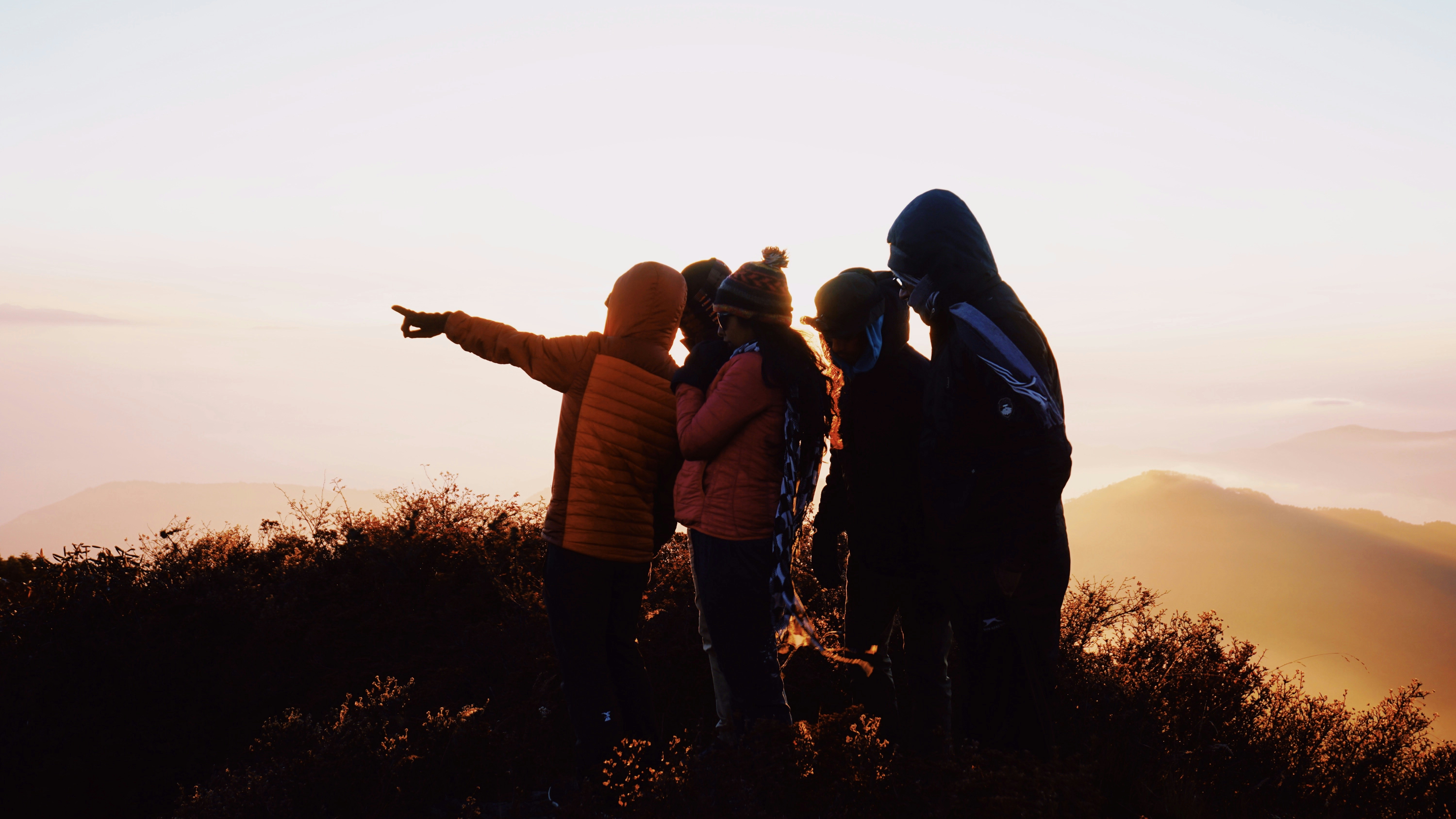 group of people standing on hill during sunrise