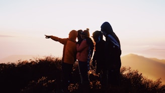 group of people standing on hill during sunrise