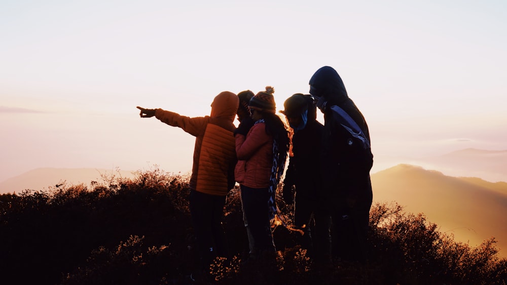 group of people standing on hill during sunrise