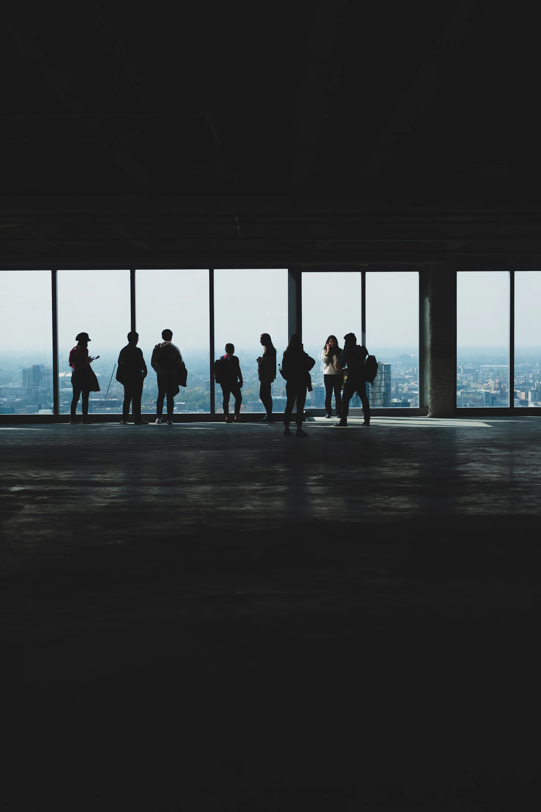 Silhouettes of people at the windows of a tower