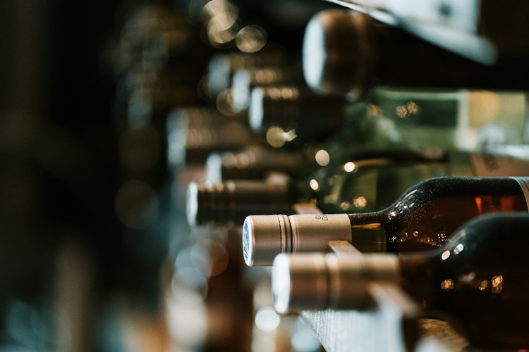 A diner holding a smartphone up to a wine bottle label at a restaurant table