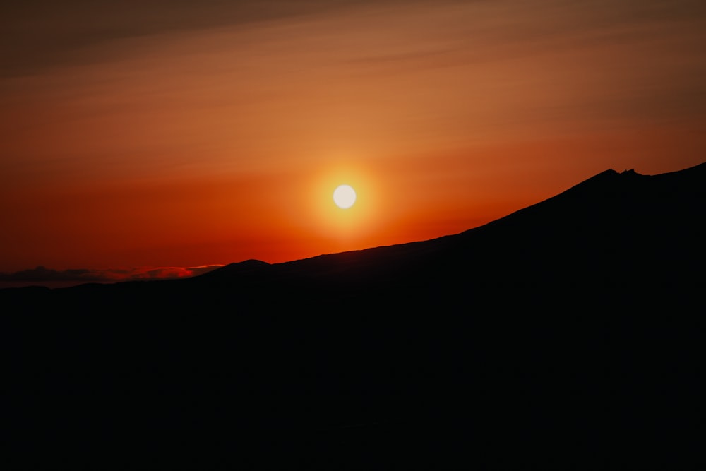 Die Sonne geht über einer Bergkette unter