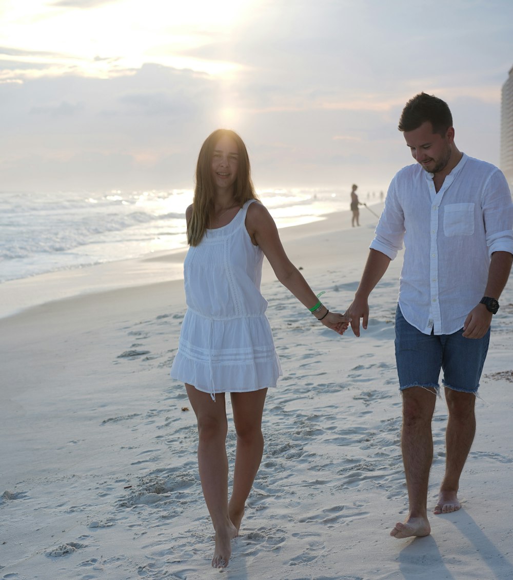 man and woman walking on seashore