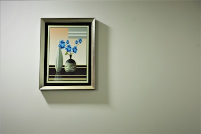 Artistic framed painting hanging on a clean white wall