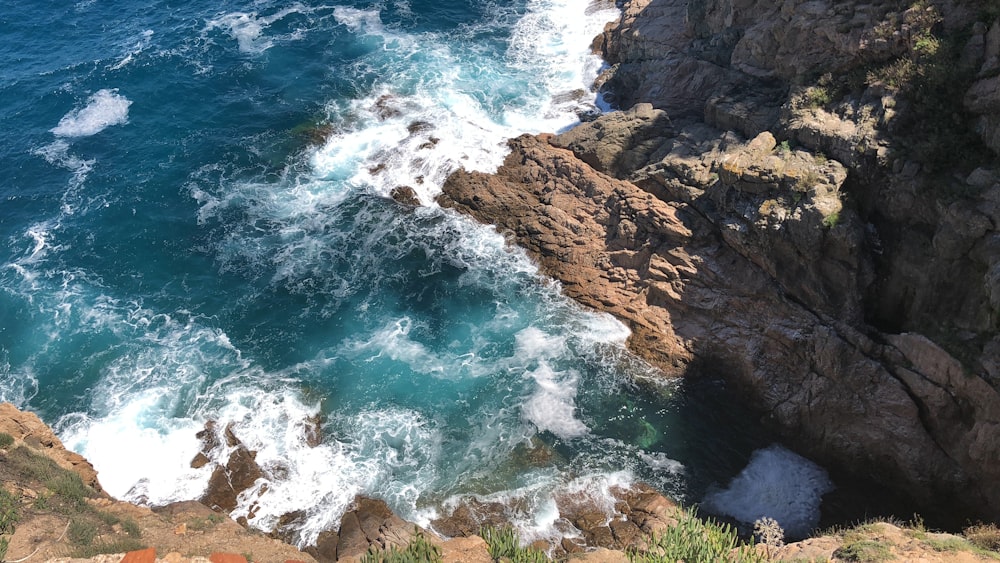 brown rock formations on sea