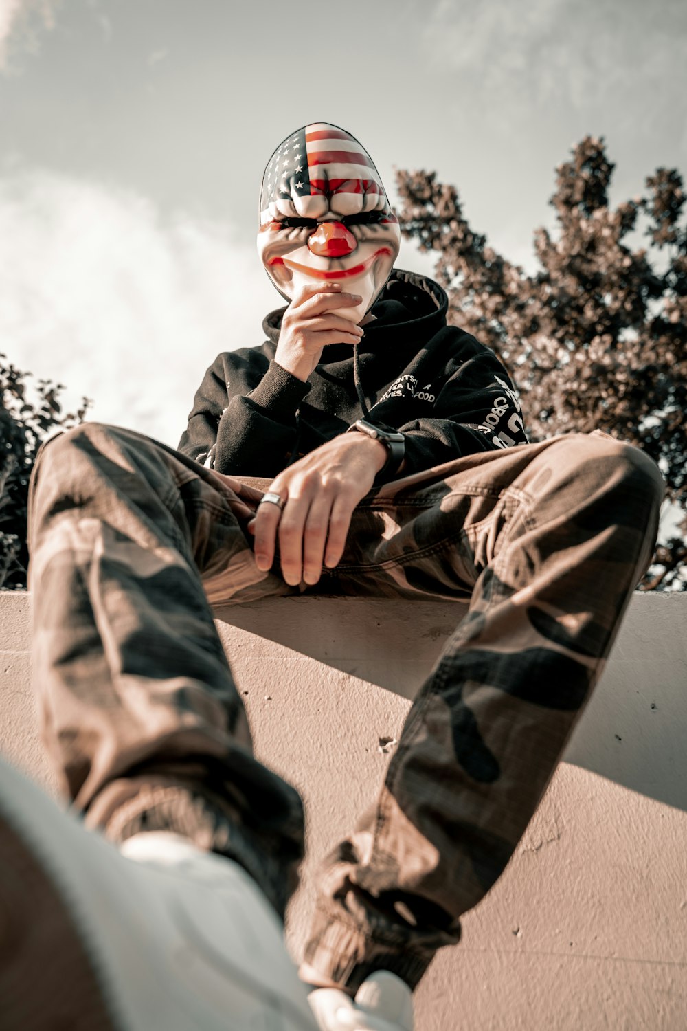 man holding multicolored clown mask