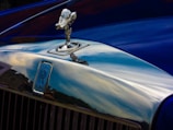 A close-up of a shiny car hood reflecting the Himalayan mountains