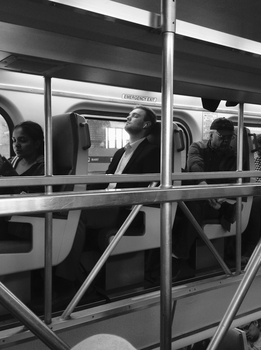 grayscale photography of people sitting inside train