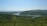 A serene landscape featuring a lush green forest under a clear blue sky.