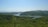 A serene landscape featuring a lush green forest under a clear blue sky.