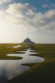 photo of grass field and spiral lake and gray castle scenery