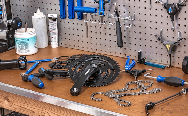 Bicycle multi-tool and repair kit laid out on a workbench ready for trail maintenance