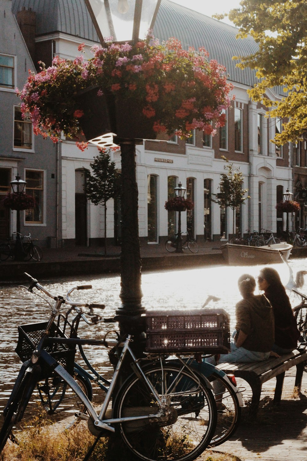 two women sitting on bench near river