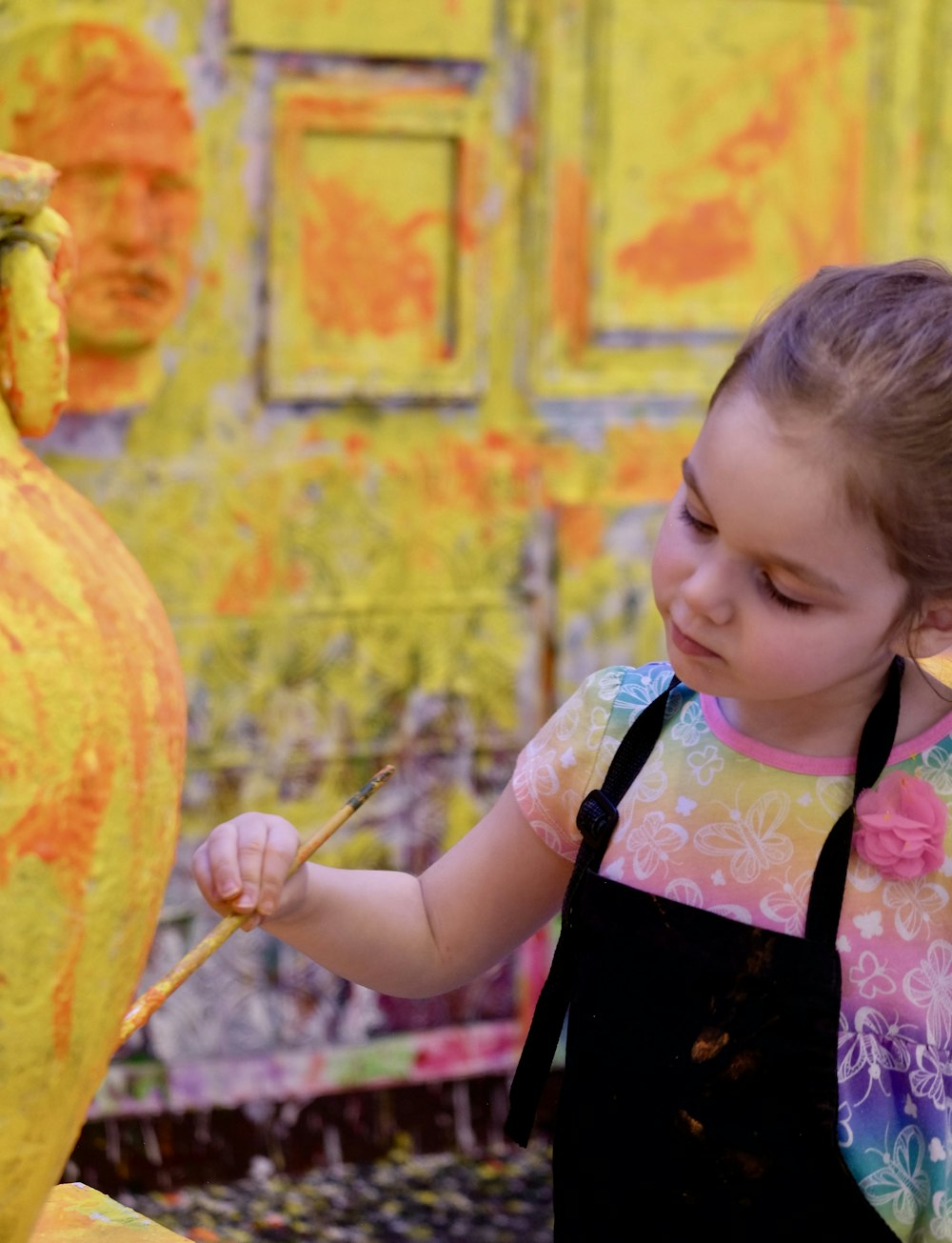 girl wearing black apron painting close-up photography