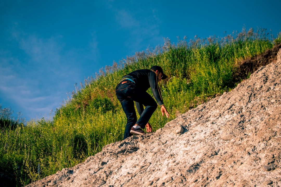 person in black long-sleeved shirt climbing mountain during daytime
