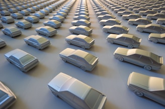 Rows of shiny new cars lined up in a distribution lot.