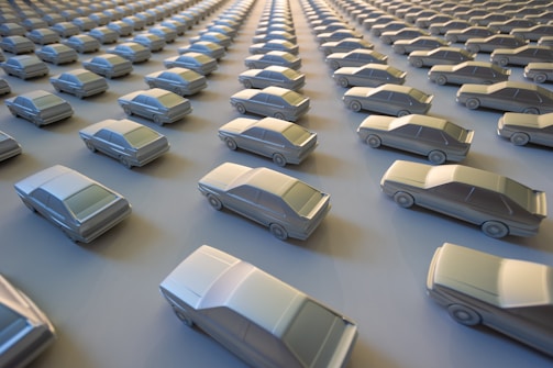 Rows of shiny new cars lined up in a distribution lot.