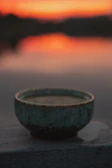 Hand-thrown clay bowl with deep blue glaze catching warm morning light.