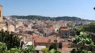 A panoramic view from a high terrace showcasing the Norman countryside and distant village rooftops.