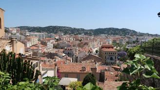 A panoramic view from a high terrace showcasing the Norman countryside and distant village rooftops.