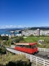 red train on rail with cityscape view underlue sky