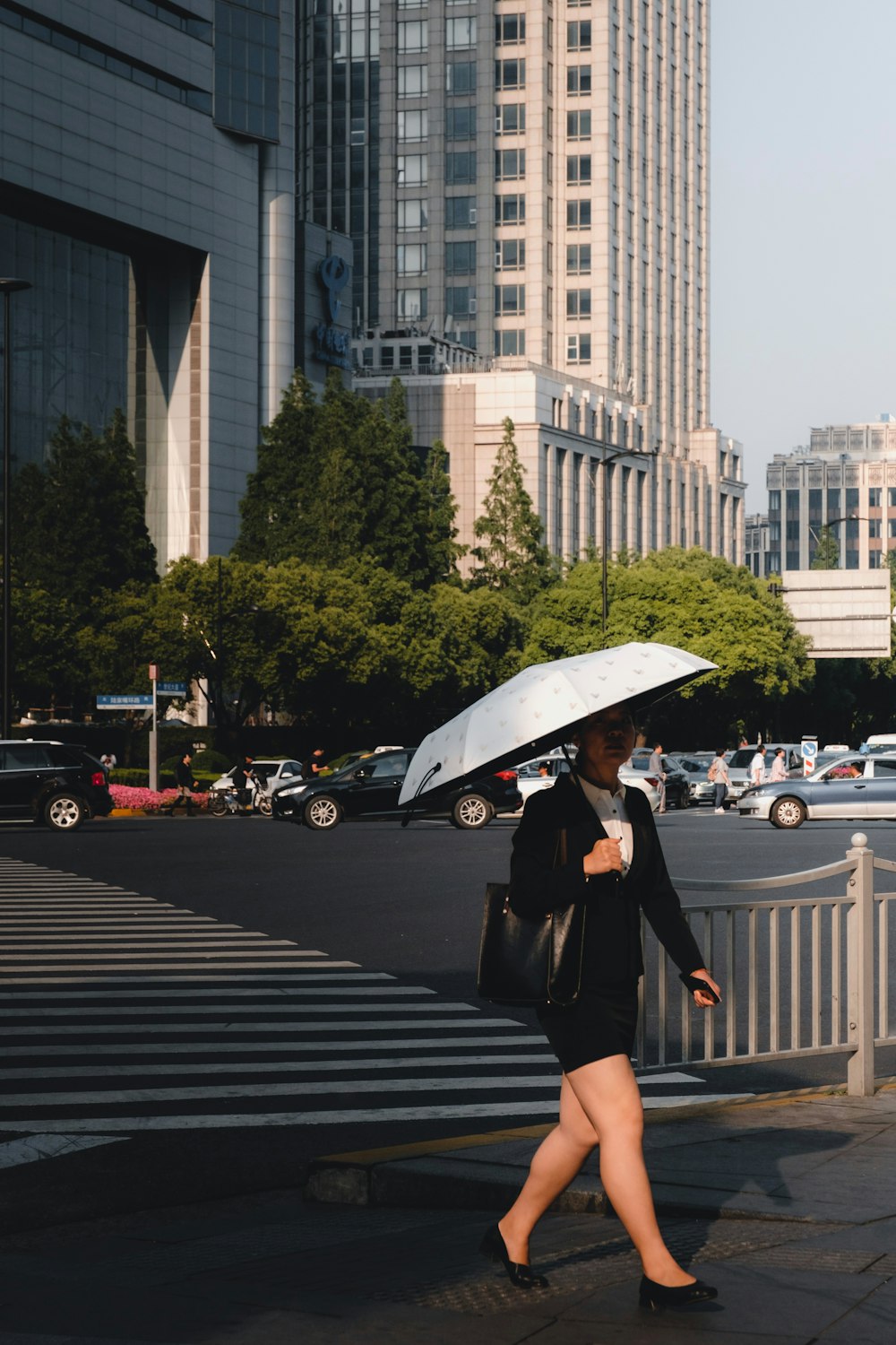 woman walking on street while holding umbrella