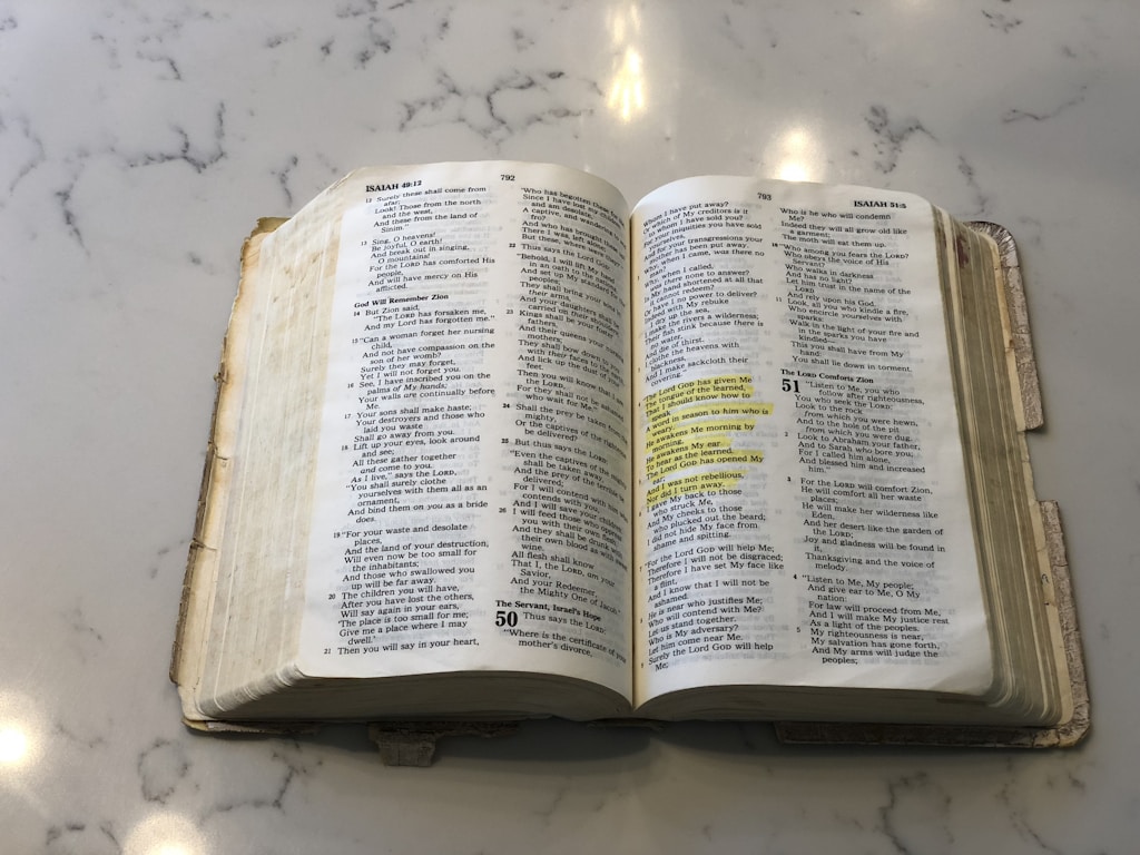 opened bible on white surface