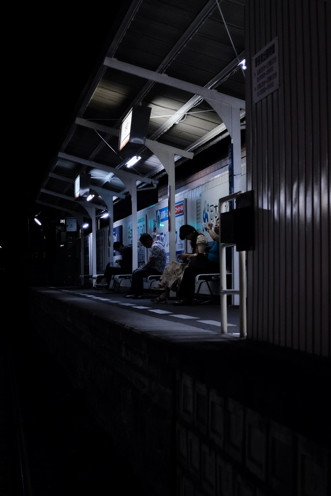 people in a waiting shed during nighttime