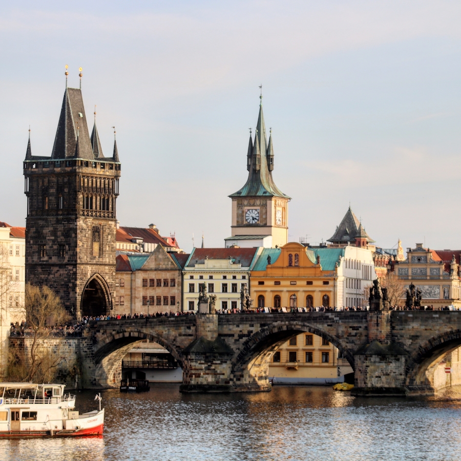 Panoramic view of Prague skyline with Vltava River, bridges, and castle in background