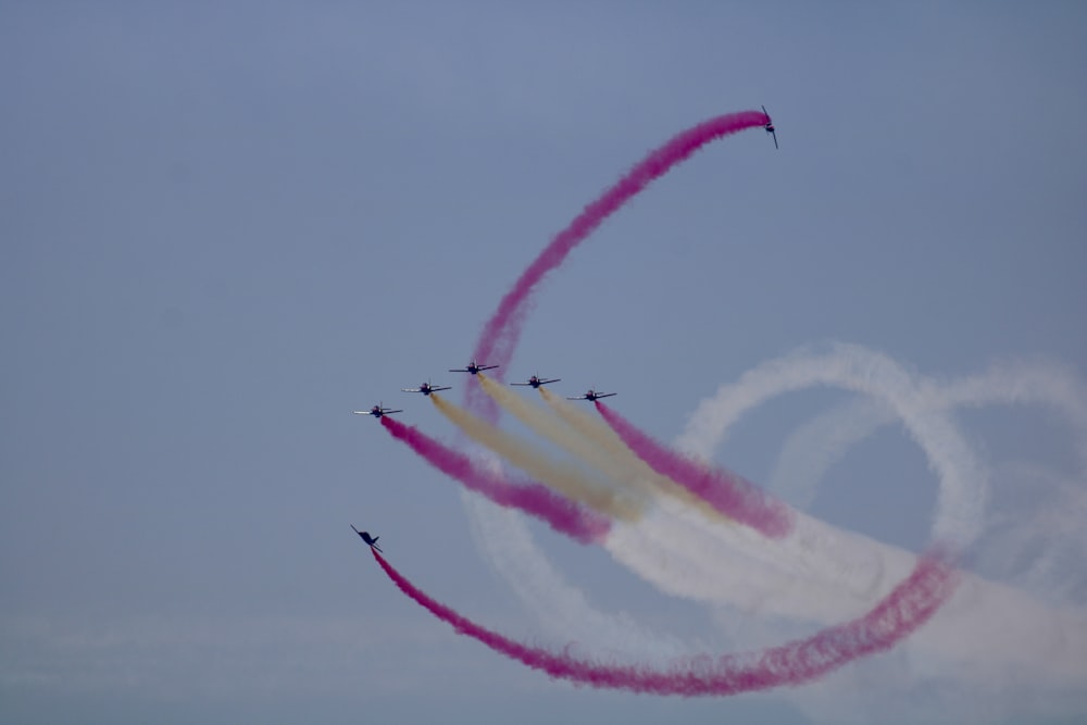 a group of jets flying through a blue sky