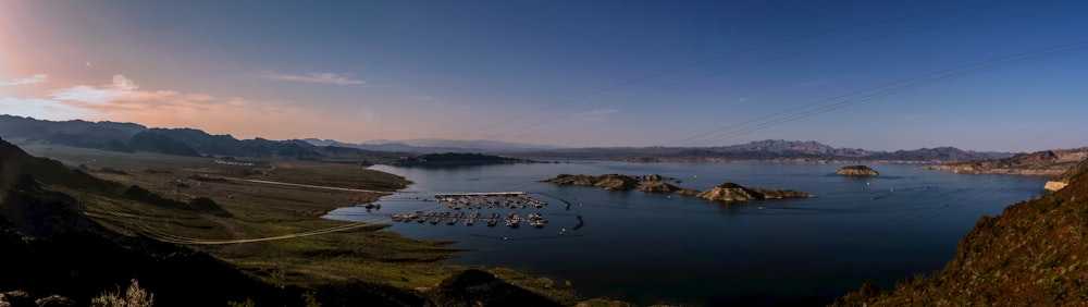 body of water near mountain during daytime