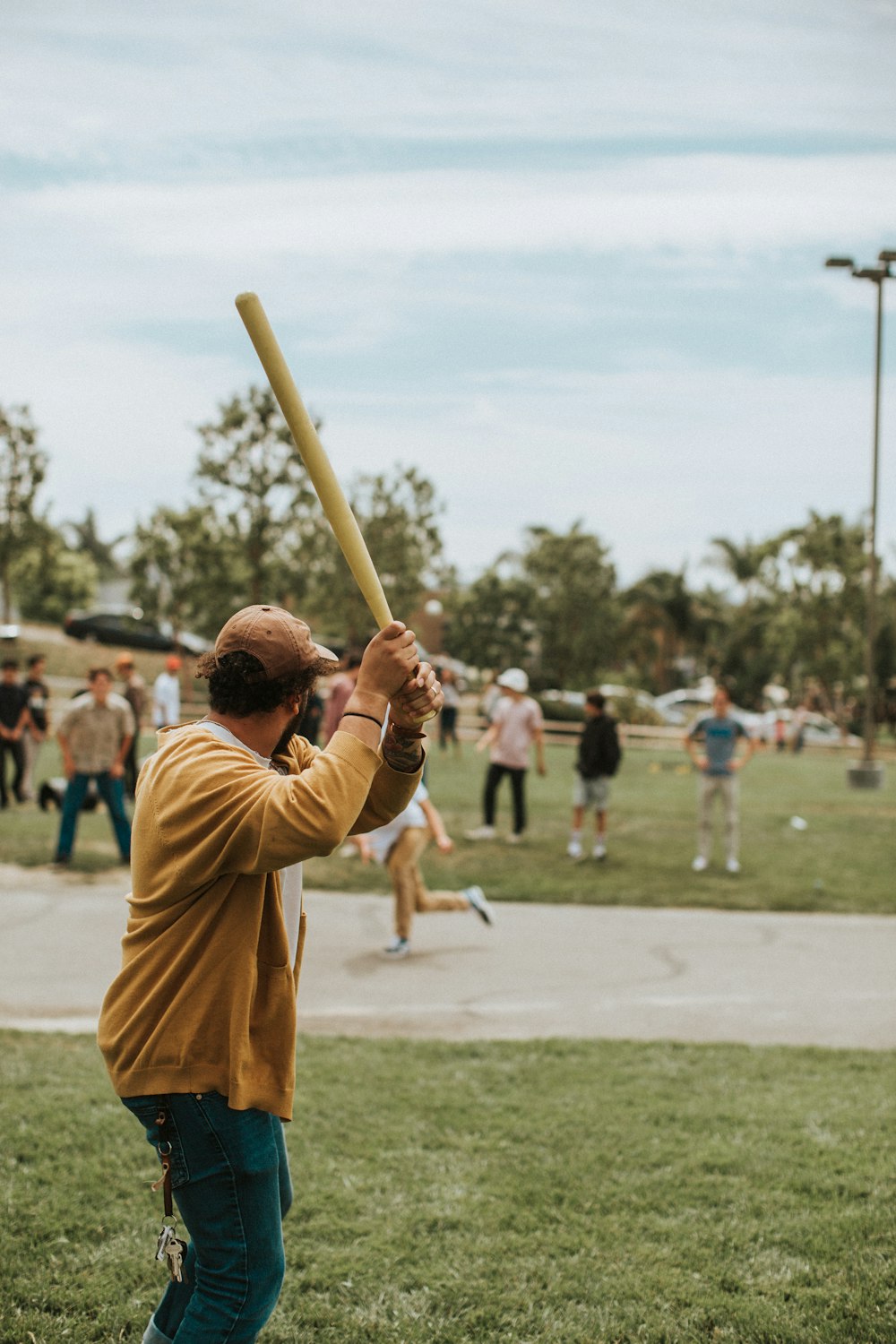 hombre sosteniendo un bate de béisbol durante el día