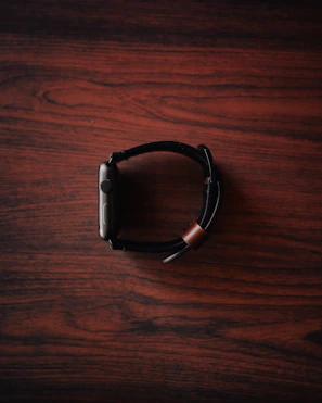 Close-up of a trendy smartwatch with a sleek design on a wooden table.