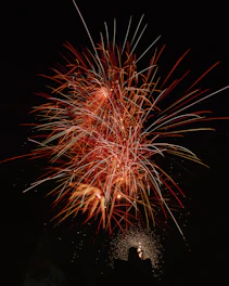 Bright fireworks bursting in vibrant colors over a romantic outdoor wedding setting.