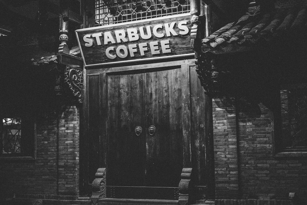 grayscale photo of Starbucks Coffee signboard
