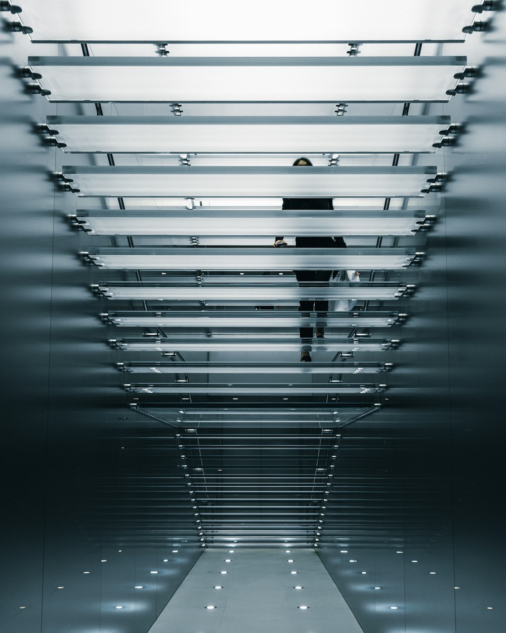 person on glass stair photo