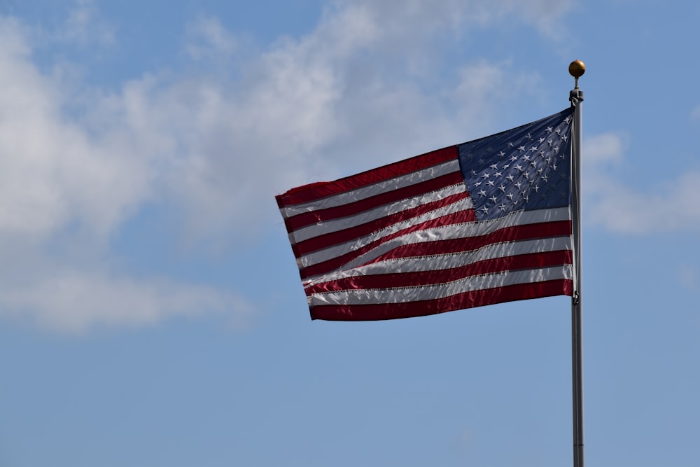 red, white, and blue USA flag in pole