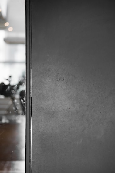 A freshly painted modern living room wall in soft gray with a smooth matte finish.