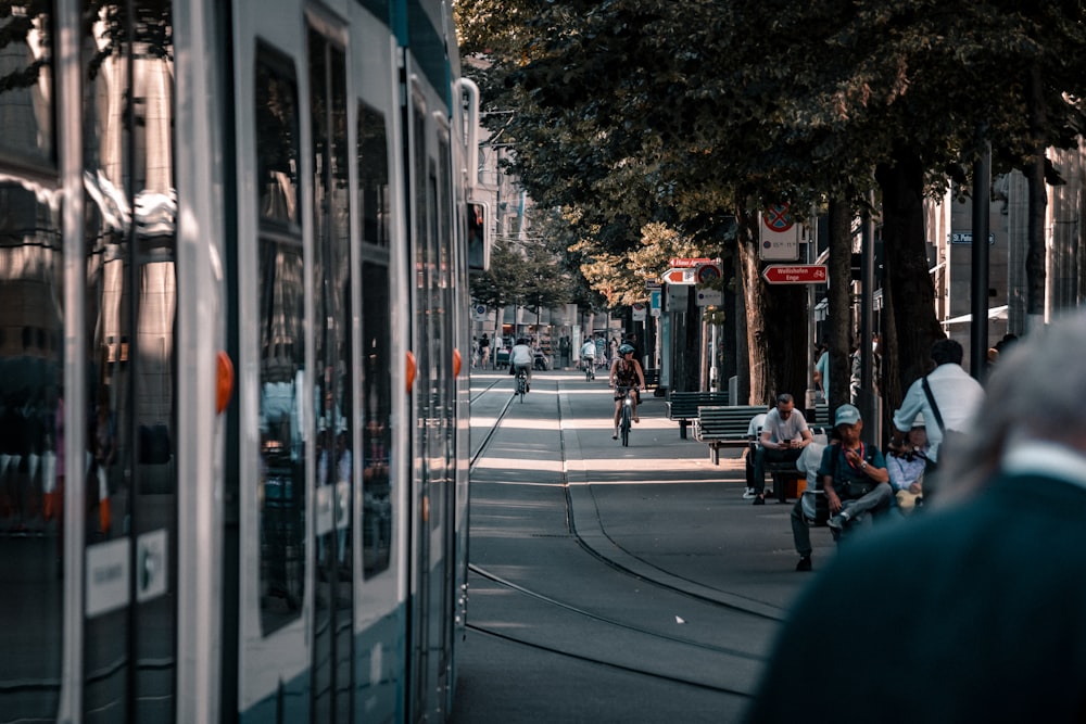 people sitting beside road at daytime