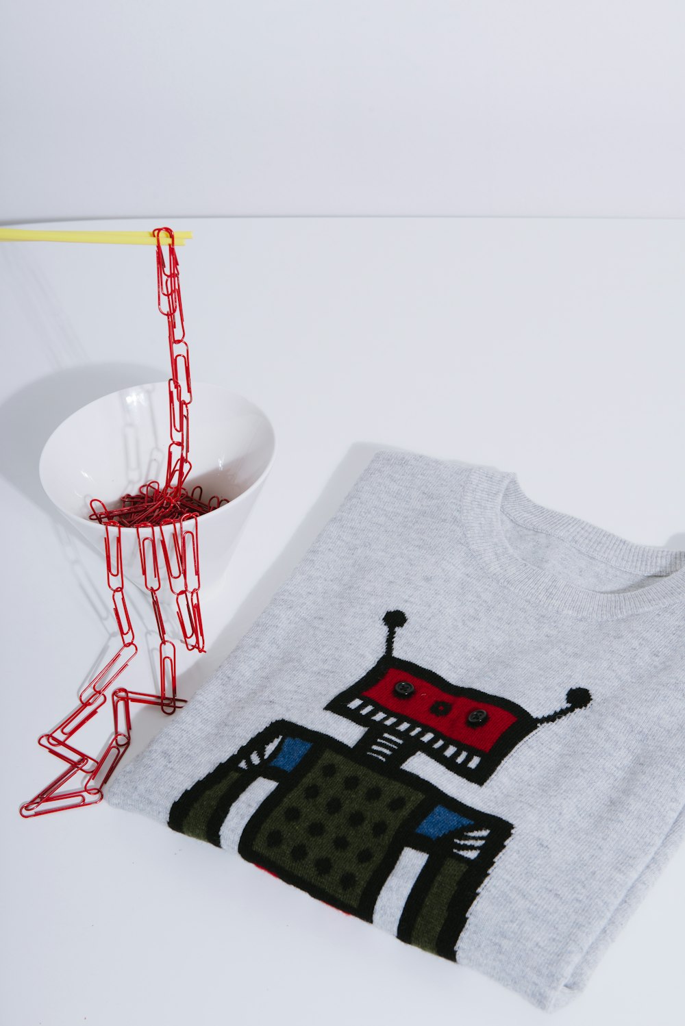 gray crew-neck shirt beside cup