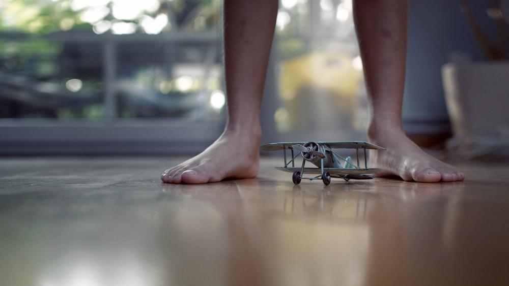 grey biplane scale model on floor