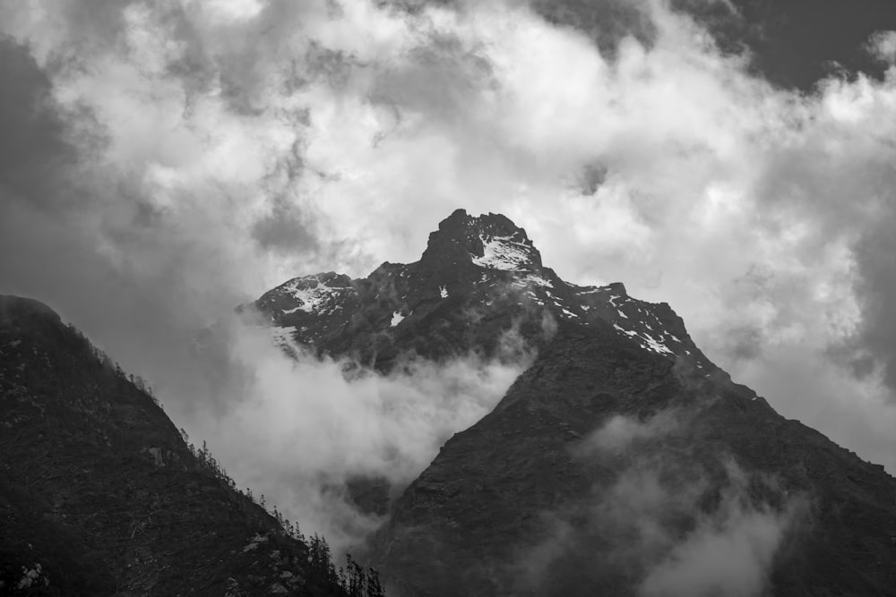 grayscale photography of mountain and clouds