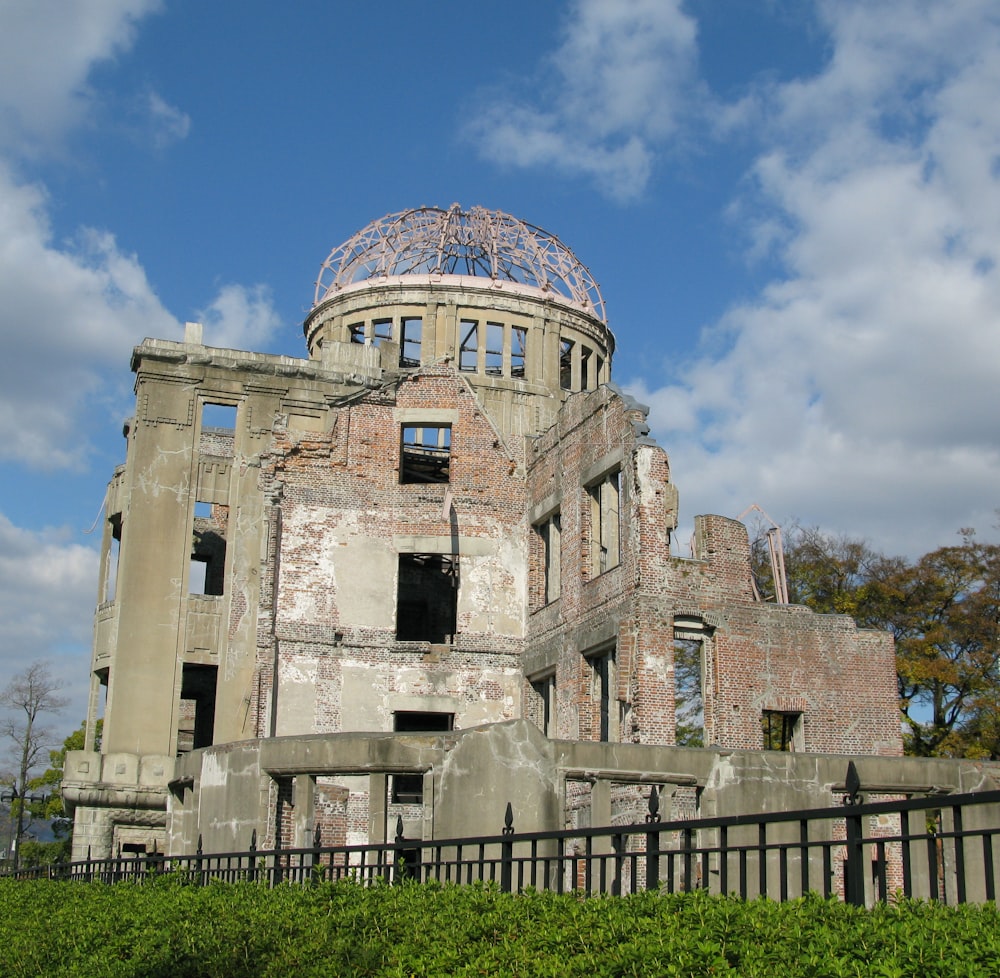 graue Betonruine in der Nähe eines grünblättrigen Baumes