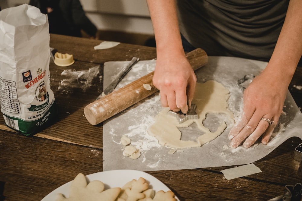 person cutting dough on table