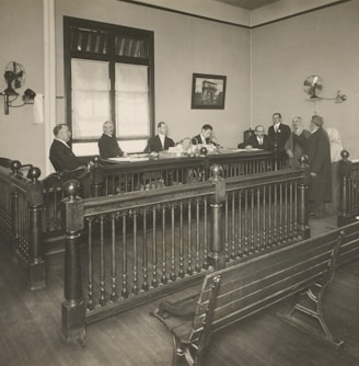 a group of men standing around a wooden desk