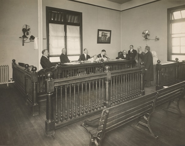 a group of men standing around a wooden desk