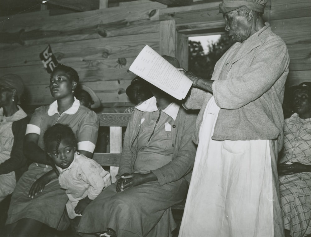 a black and white photo of a woman reading a book