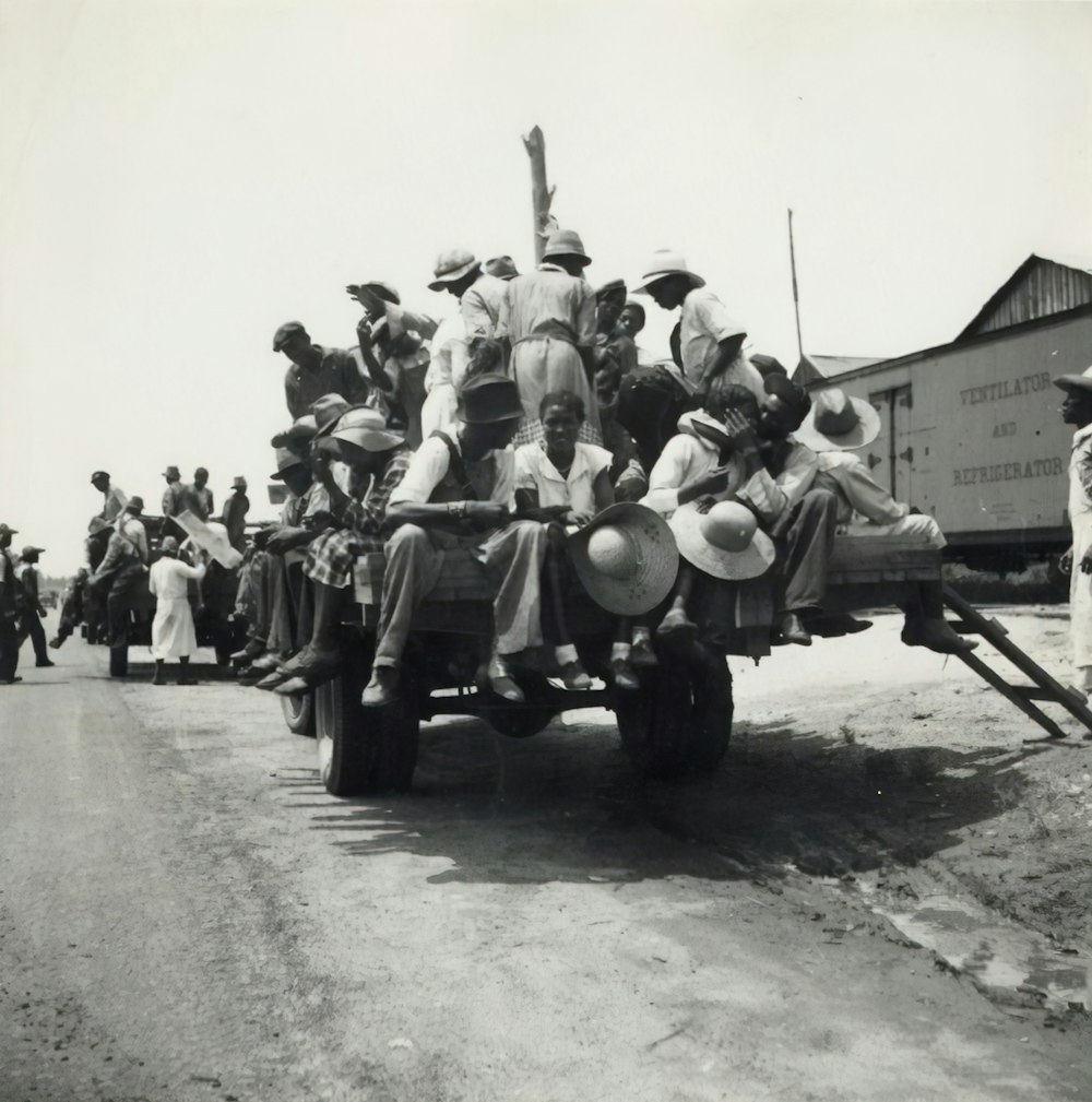 grayscale photography of people riding truck
