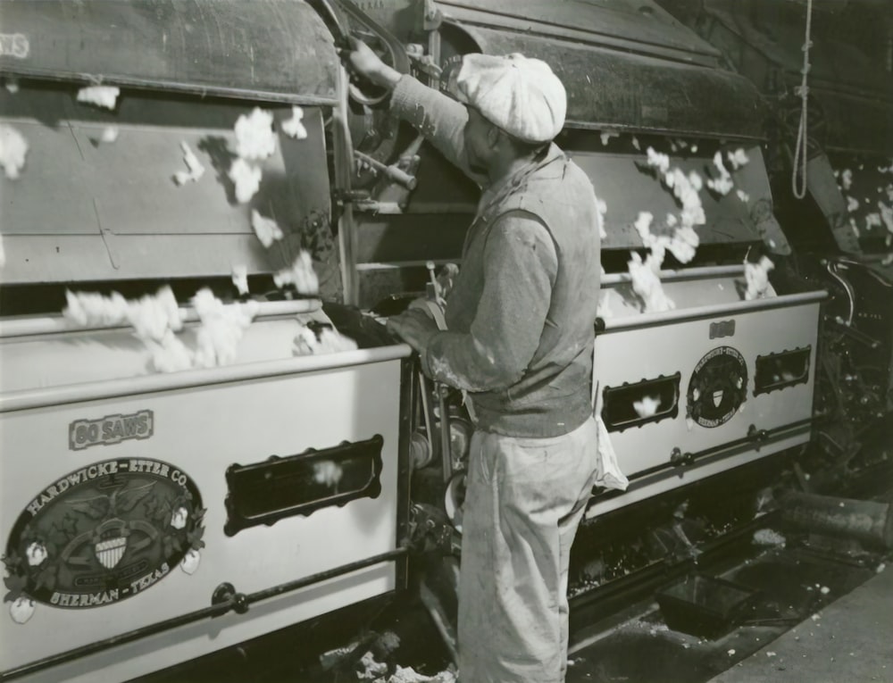 man in cap near machine